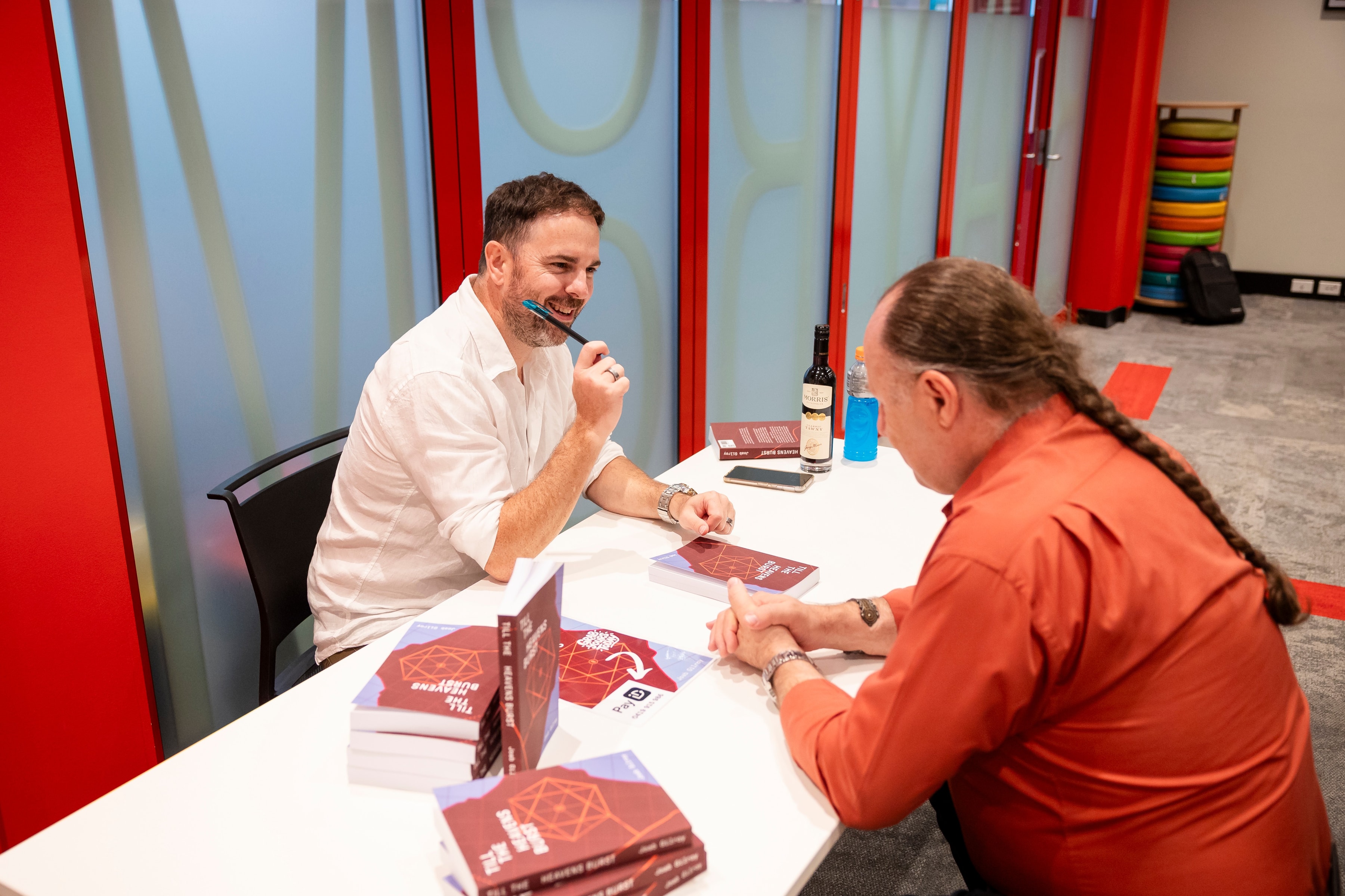 Joab gestures with his pen while he procrastinates from signing books