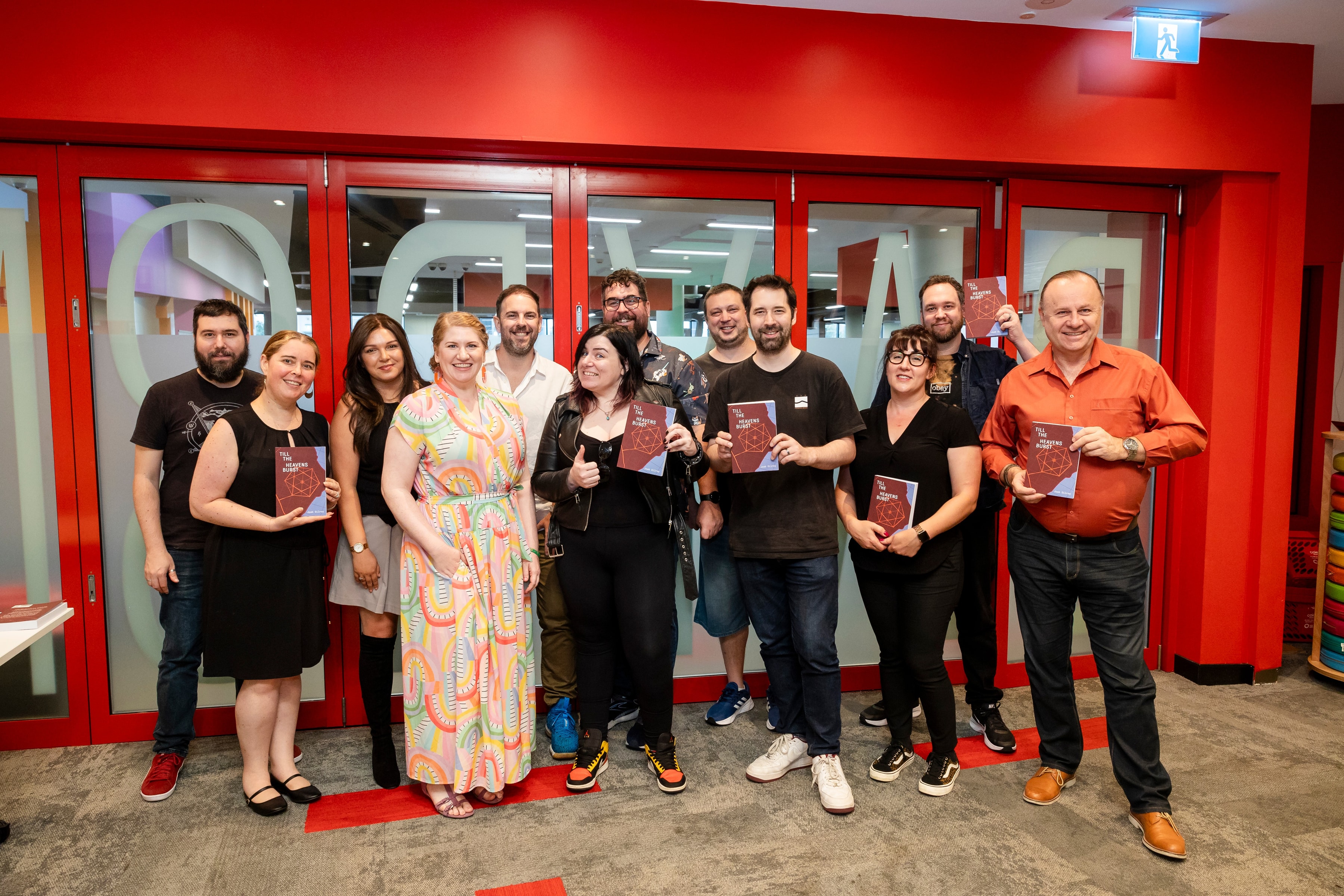 A heap of wonderful and beautiful people stand together for a group photo at the book launch of Till The Heavens Burst